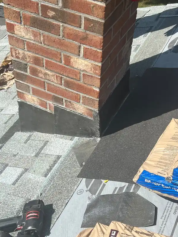 Chimney with new step flashing going in against fresh underlayment